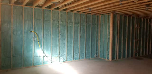 Closed-cell spray foam filling the stud cavities of a framed interior wall