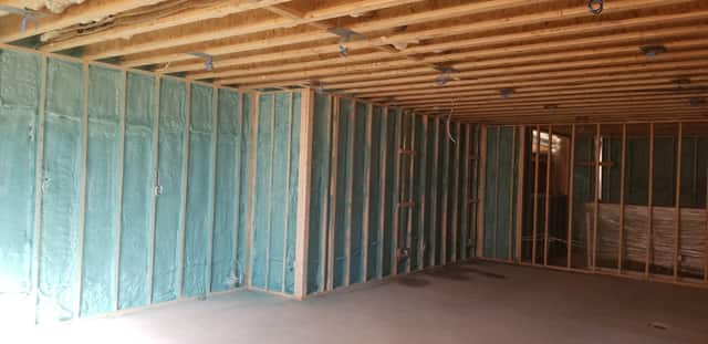 Closed-cell spray foam filling the stud cavities of a framed interior wall