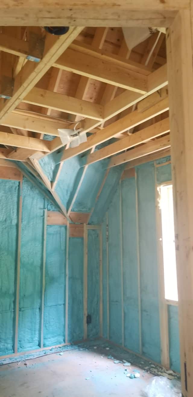 Closed-cell spray foam filling the stud cavities of a framed interior wall