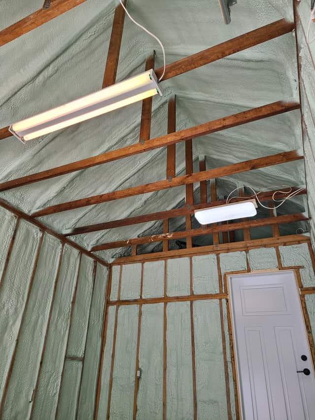 Spray foam applied between roof rafters, sealing the underside of the roof deck