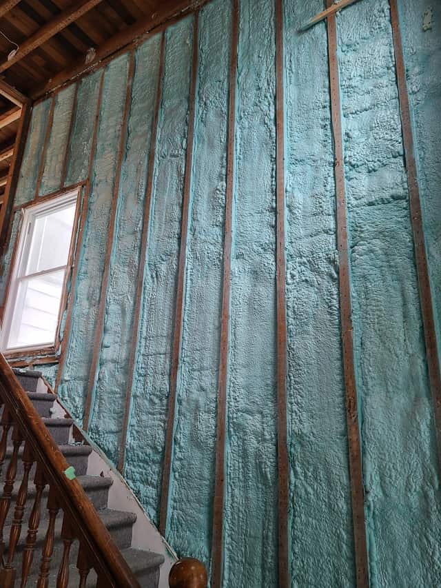 Spray foam applied between roof rafters, sealing the underside of the roof deck