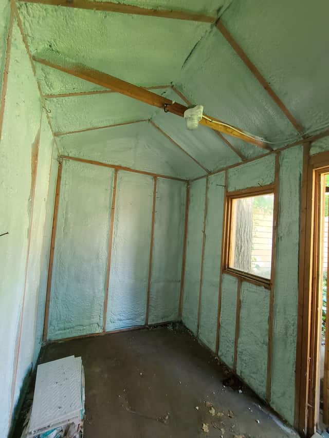 Closed-cell spray foam filling the stud cavities of a framed interior wall