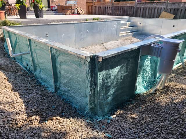 A pool shell insulated with spray foam before backfilling