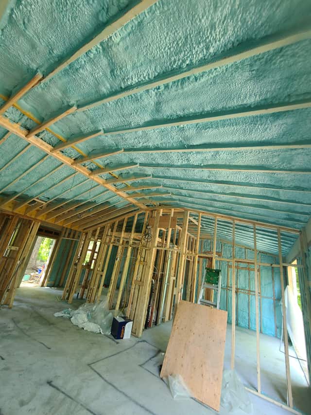 Spray foam applied between roof rafters, sealing the underside of the roof deck