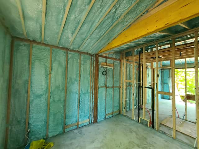 Closed-cell spray foam filling the stud cavities of a framed interior wall