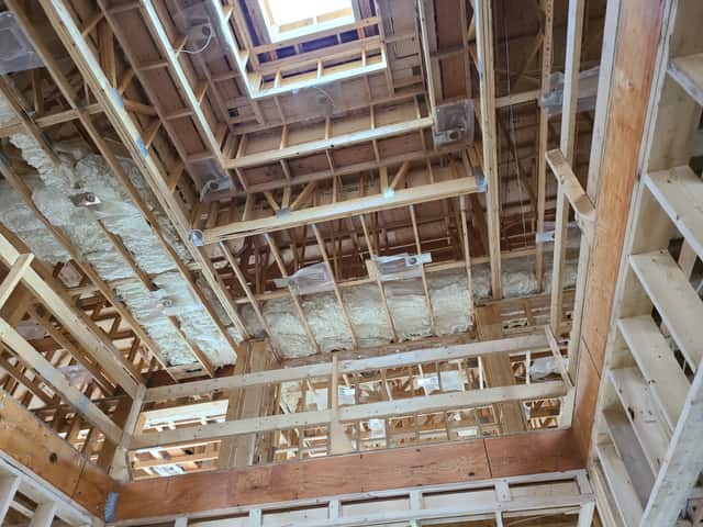 Spray foam applied between roof rafters, sealing the underside of the roof deck