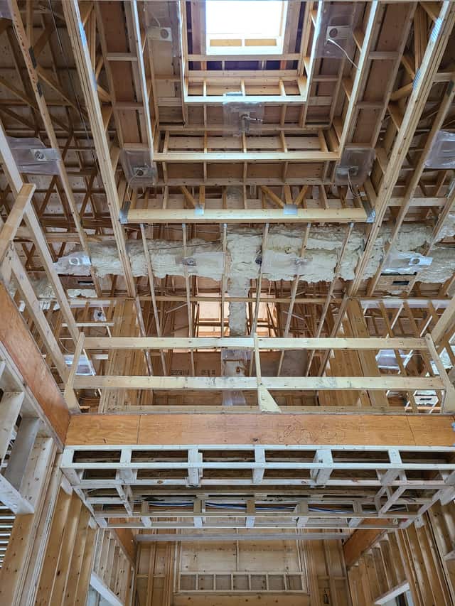 Spray foam applied between roof rafters, sealing the underside of the roof deck
