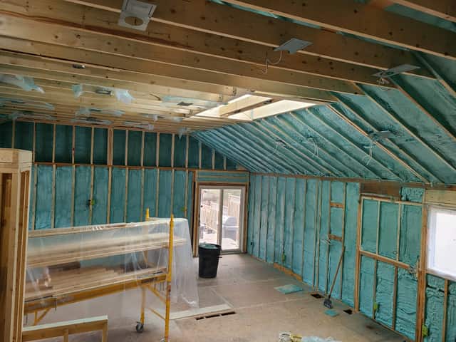 Spray foam applied between roof rafters, sealing the underside of the roof deck