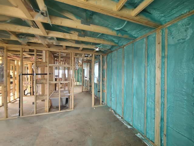 Closed-cell spray foam filling the stud cavities of a framed interior wall
