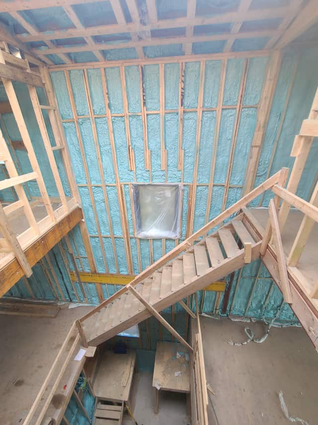Spray foam applied between roof rafters, sealing the underside of the roof deck