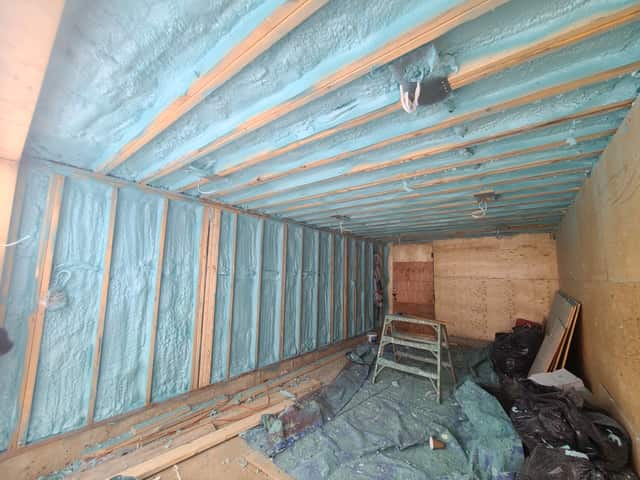 Spray foam applied between roof rafters, sealing the underside of the roof deck