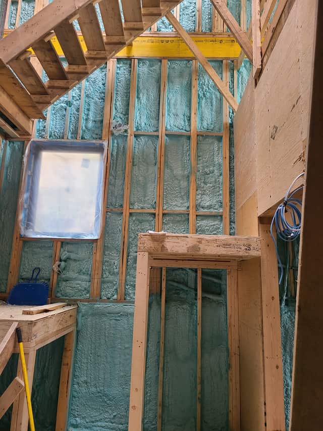 Closed-cell spray foam filling the stud cavities of a framed interior wall