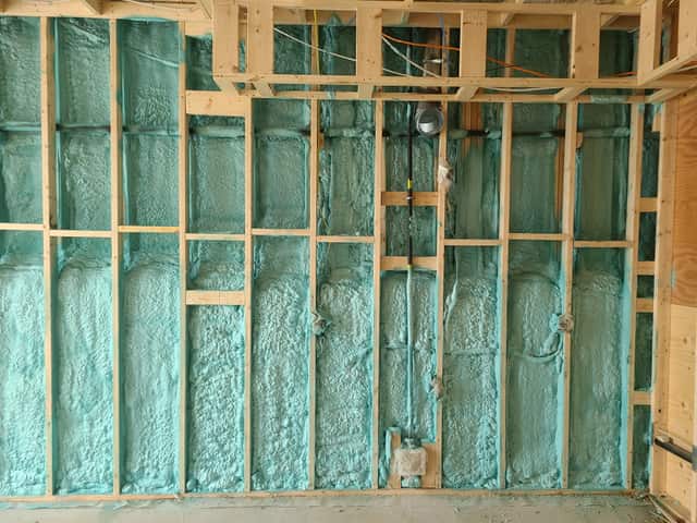 Closed-cell spray foam filling the stud cavities of a framed interior wall