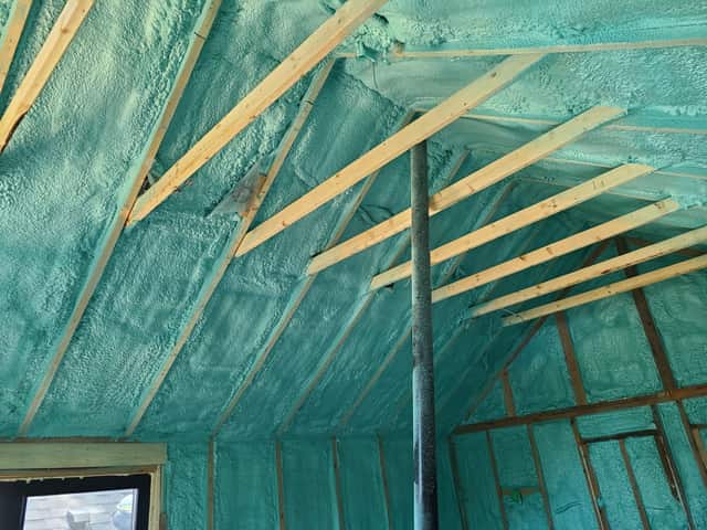 Spray foam applied between roof rafters, sealing the underside of the roof deck