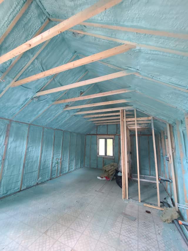 Spray foam applied between roof rafters, sealing the underside of the roof deck