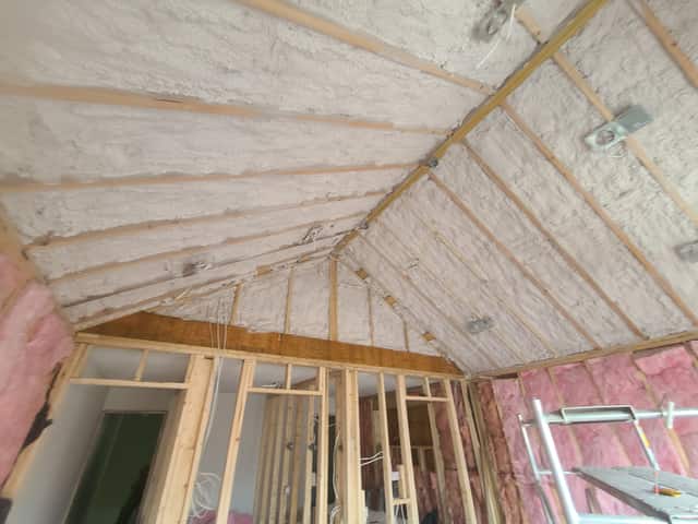 Spray foam applied between roof rafters, sealing the underside of the roof deck