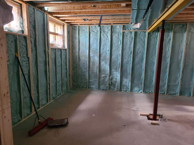 Closed-cell spray foam filling the stud cavities of a framed interior wall