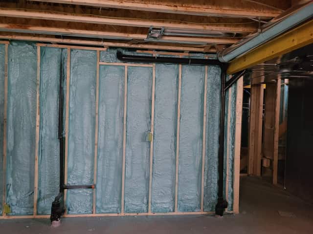 Closed-cell spray foam filling the stud cavities of a framed interior wall