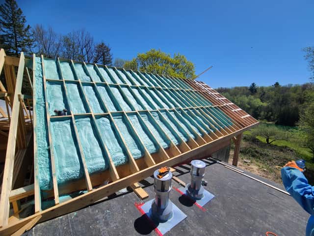 Spray foam applied between roof rafters, sealing the underside of the roof deck