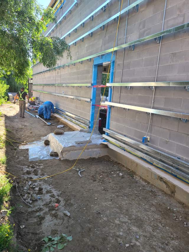The exterior wall of a commercial building being insulated with spray foam