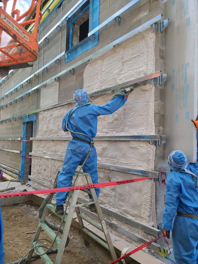 Fahrenheit Foam crew in full protective suits and respirators spraying foam on a roof