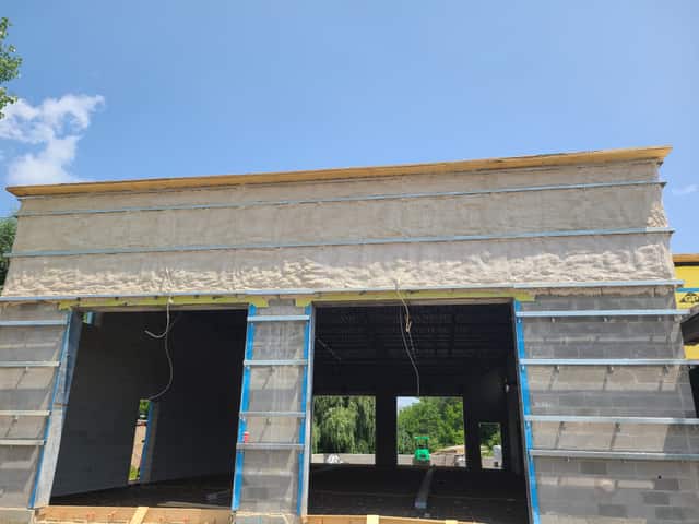 The exterior wall of a commercial building being insulated with spray foam