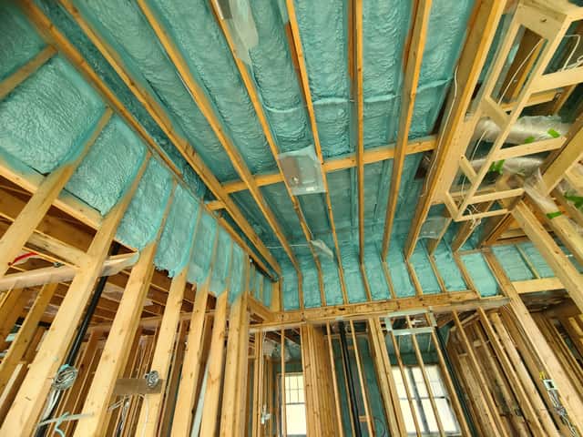 Spray foam applied between roof rafters, sealing the underside of the roof deck