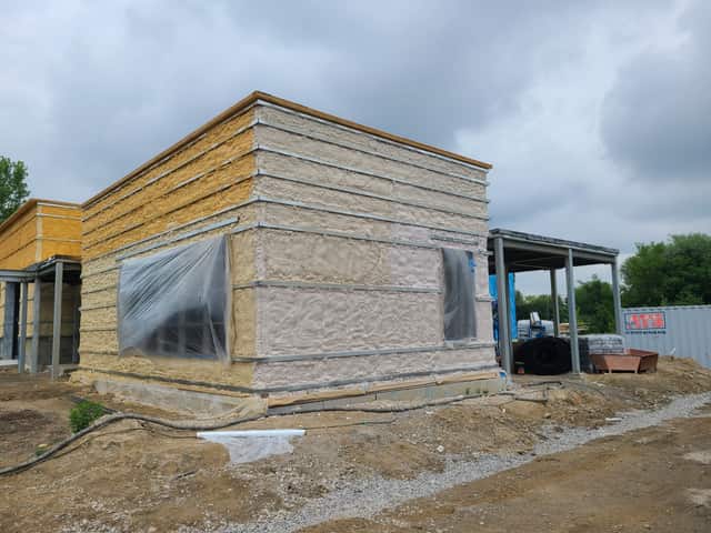 The exterior wall of a commercial building being insulated with spray foam
