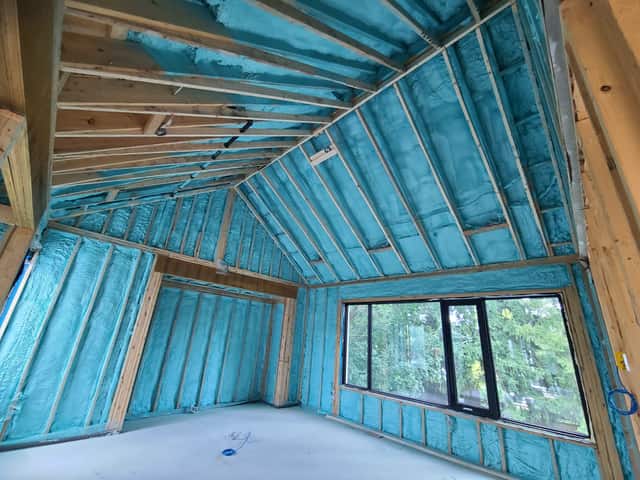 Closed-cell spray foam filling the stud cavities of a framed interior wall