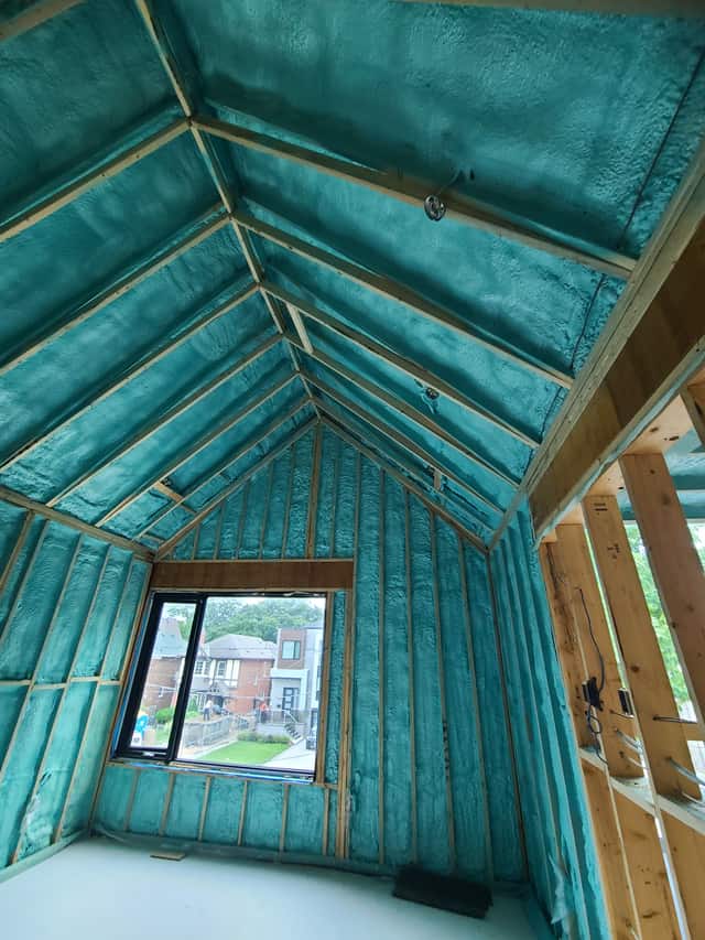 Spray foam applied between roof rafters, sealing the underside of the roof deck