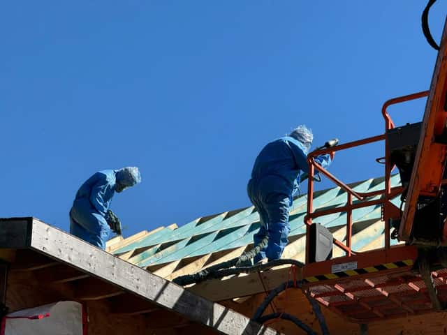 Fahrenheit Foam crew in full protective suits and respirators spraying foam on a roof