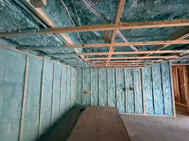 Closed-cell spray foam filling the stud cavities of a framed interior wall