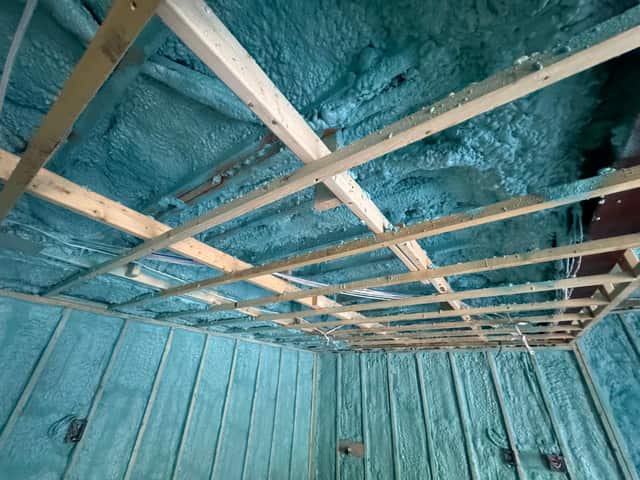 Spray foam applied between roof rafters, sealing the underside of the roof deck