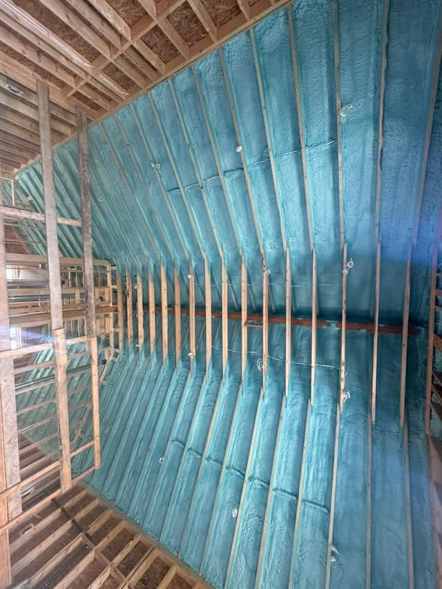 Closed-cell spray foam filling the stud cavities of a framed interior wall